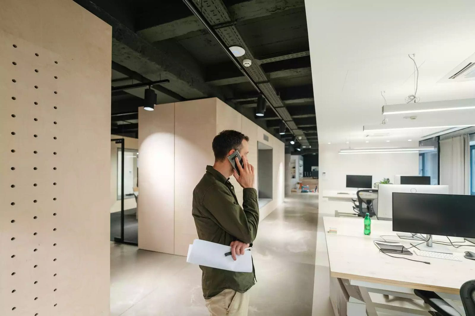 Man on the phone surrounded by defense contractor office furniture