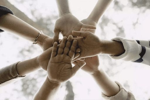 Happy employees joining hands