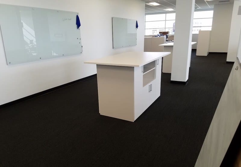 High-top collaboration table and glass whiteboards at United Grinding North America