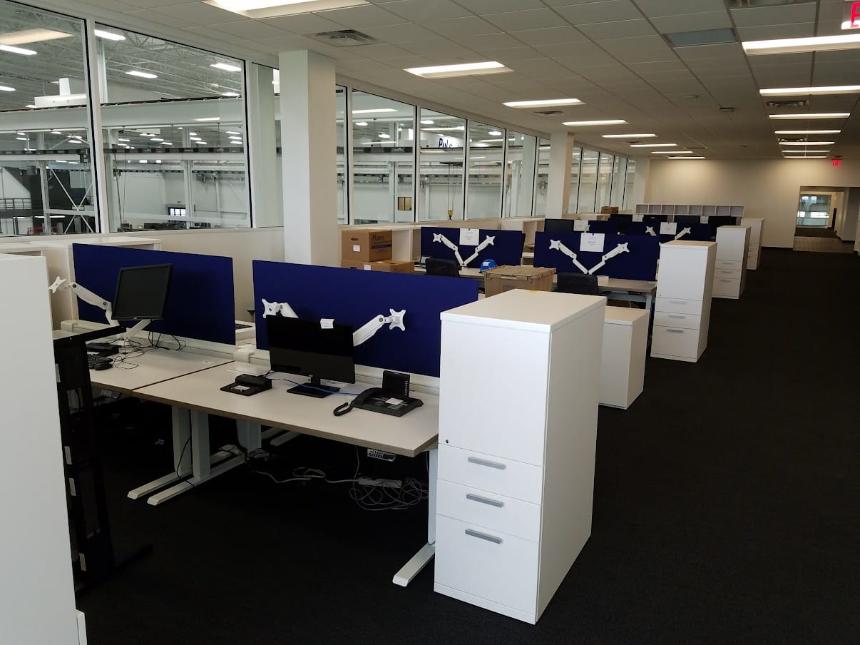High-top collaboration table and glass whiteboards at United Grinding North America