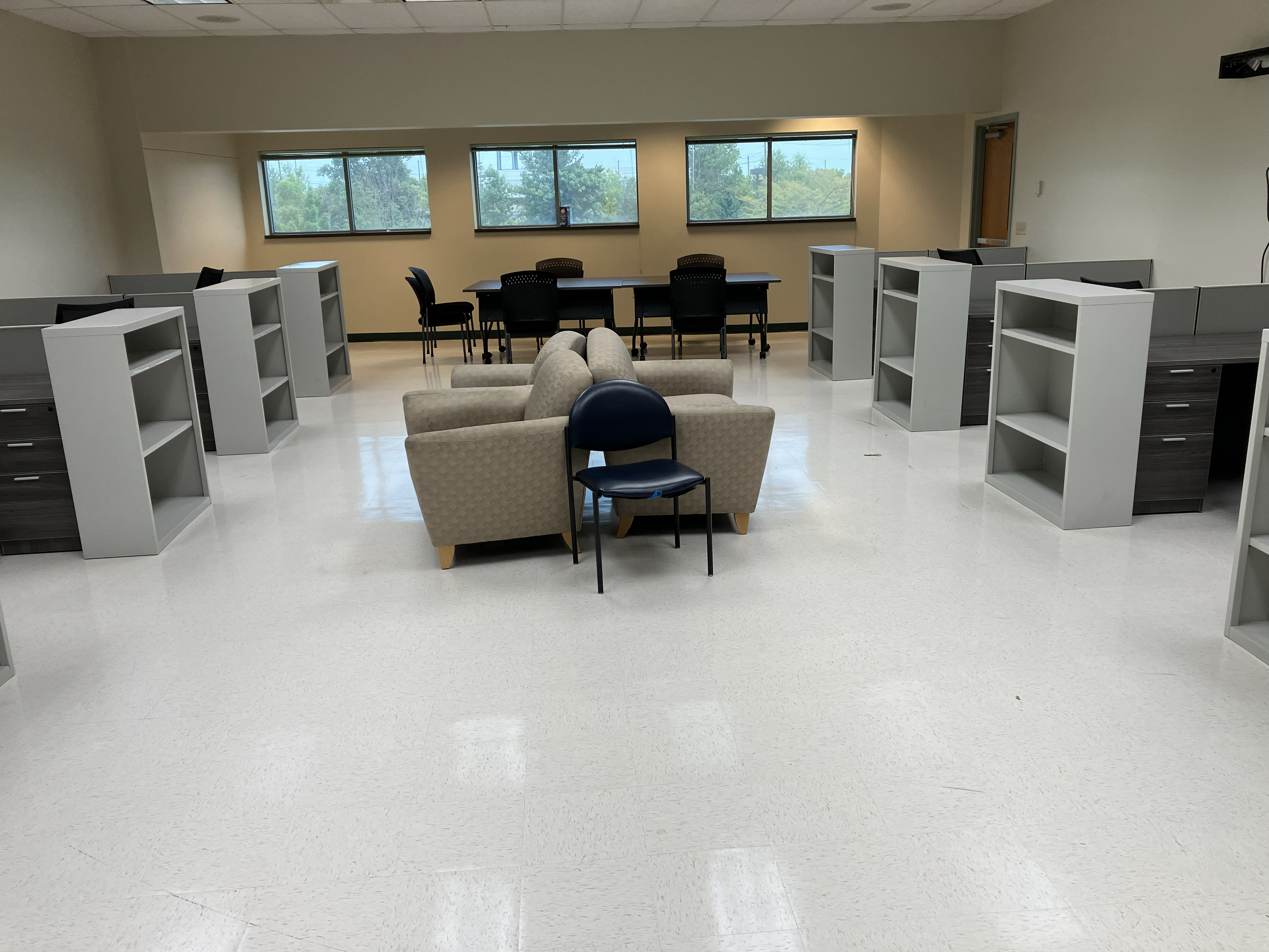 Open office with lounge chairs, a conference table, and bookcases.