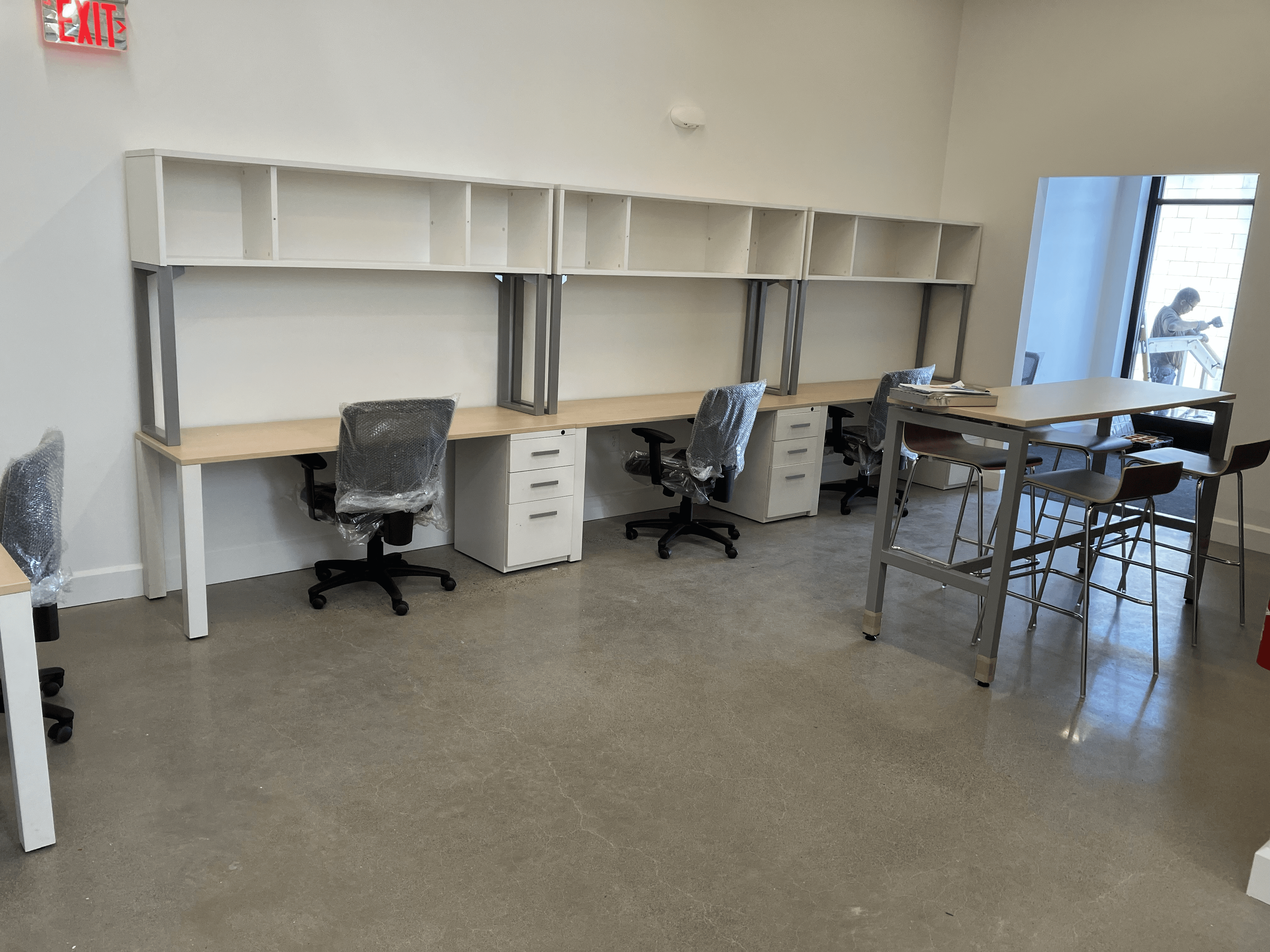 Three 6 foot maple desks with white overhead storage and metal legs