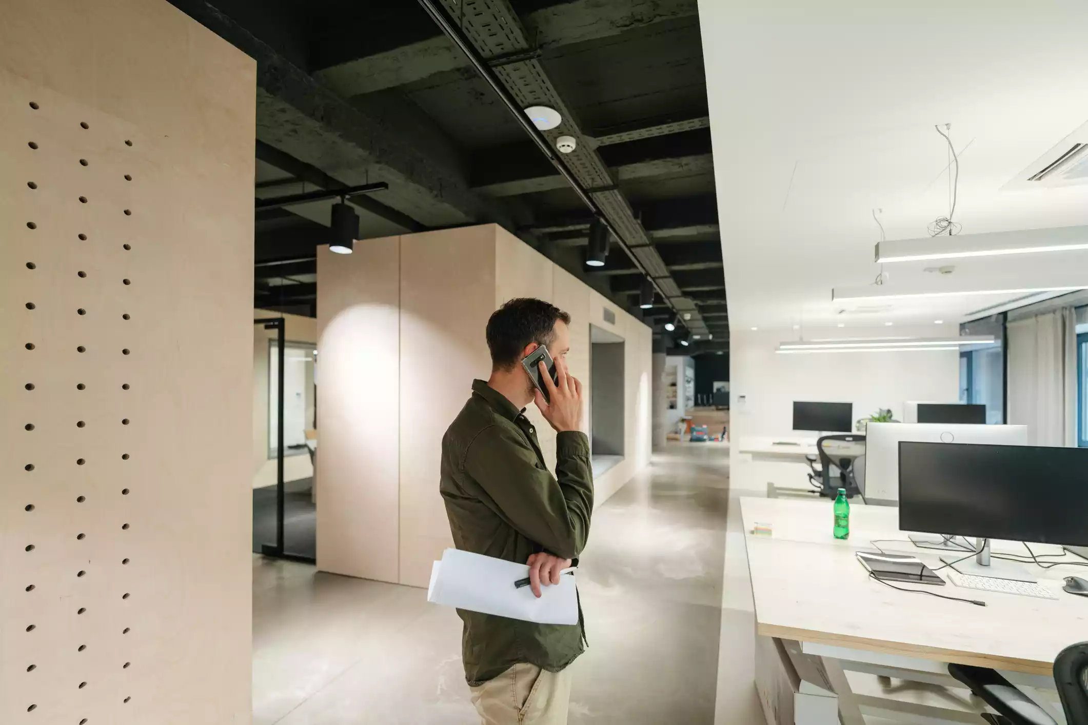 Man on the phone surrounded by defense contractor office furniture